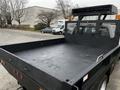 2015 Ford F-550 flatbed truck with a black bed and metal mesh back panel