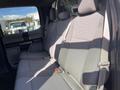 A 2019 Ford F-350 SD with gray fabric seating in the rear passenger area showing two seat belts and a spacious design