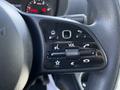 Close-up of the steering wheel controls of a 2022 Mercedes-Benz Sprinter featuring buttons for volume and phone functions