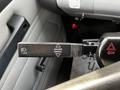 A black lever labeled with icons indicating lift and hazard cancel features in the cab of a 1994 Freightliner FL80