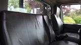 Interior view of a 2010 International 4300 showing two black leather seats and the driver's seat silhouette