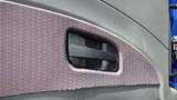 A door handle on the interior of a 2012 International DuraStar 4300 truck with a textured fabric panel surrounding it