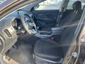 Interior of a 2012 Kia Sportage featuring black cloth seats a center console with an infotainment display and various controls on the dashboard
