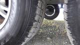 Close-up of two tires of a 2021 Forest River 312BH East To West Della Terra showing tread patterns and the underside of the trailer