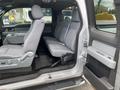 A 2013 Ford F-150 interior view showing the back seat area with gray cloth seating and a floor mat