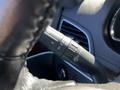 Close-up of a steering wheel control stalk with buttons for headlights and windshield wipers in a 2013 Lincoln MKT