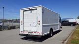 A white 2006 Ford Econoline cargo van parked in a lot with a plain rear design and a visible loading door