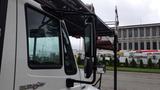 A 2010 International 4300 truck with a prominently displayed side mirror and a protective grill on the window