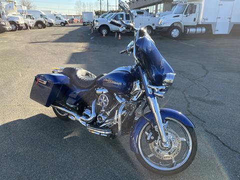 A 2017 Harley-Davidson FLHXS in a deep blue color with a sleek design features saddlebags a large front wheel and chrome accents