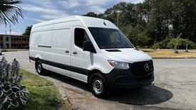 2022 Mercedes-Benz Sprinter 2500 white cargo van with a sleek design and black accents parked on a driveway