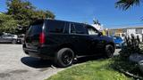 A black 2018 Chevrolet Tahoe parked at an angle with black rims and tinted windows