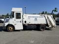 2010 Freightliner MT45 Garbage Truck with a side-loading mechanism and markings for Waste Reduction Program