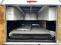 A 2012 RAM 3500 with an open cargo area featuring storage compartments and a flat surface with a metal panel resting on it