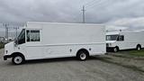 A white 2006 Ford Econoline van with a flat front and large side panels parked on gravel