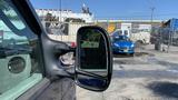 A 2013 Ford Econoline van seen from the driver's side mirror