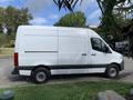 A white 2021 Mercedes-Benz Sprinter van is shown from the side with a tall upright cargo area and black trim along the bottom