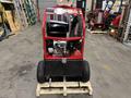 A red 2024 Magnum 4000 Hot Water Pressure Washer with a black handle and large wheels set on a wooden pallet