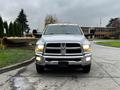 A 2018 RAM 3500 pickup truck facing forward with chrome accents and illuminated headlights