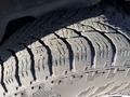 Close-up of a rugged tire tread from a 2013 Ford Expedition showing deep grooves and uneven wear indicating the surface texture and condition of the tire