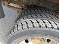 Close-up of a tire from a 2010 Ford F-550 showing a rugged tread pattern and a metallic rim