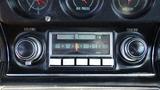 Dashboard of a 1971 Chevrolet Corvette Stingray featuring classic dials for volume and tuning along with a vintage radio display