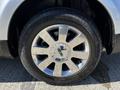 Close-up of a silver wheel from a 2013 Lincoln MKT featuring a chrome rim with a multi-spoke design and a black tire with an embossed tread pattern