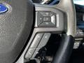 Close-up of the steering wheel controls of a 2017 Ford F-150 featuring audio and phone buttons