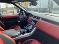 Interior of a 2020 Land Rover Range Rover Sport featuring red leather seats and a central touchscreen display with modern controls