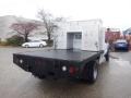 A 2009 Ford F-450 Super Duty with a flatbed and a metal storage unit attached to the rear