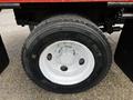 A close-up of the wheel and tire of a 2008 Ford F-750 featuring a black tire with white lettering and a silver wheel rim