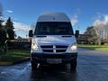 A 2008 Dodge Sprinter Van with a white exterior and a distinctive front grille featuring the Dodge emblem