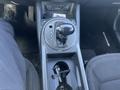 The interior console of a 2012 Kia Sportage featuring a gear shifter with drive modes and cup holders