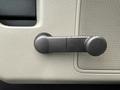 A black plastic door handle on a vehicle interior with a textured surface and a circular grip