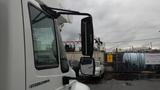 A 2005 International 4300 truck with a prominent side mirror reflecting its surroundings