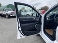 2018 Jeep Grand Cherokee with its driver door open revealing the interior features and controls