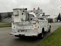 A white 2004 Ford F-450 SD utility truck with a bucket lift and storage compartments on the bed