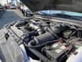 Close-up of the engine compartment of a 2003 Ford F-450 SD showing the air intake system battery and various engine components