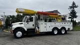 A white 2006 International 7500 truck with a yellow and red retractable aerial lift system mounted on the bed