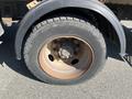 Close-up of a rusty wheel and tire from a 2010 Freightliner MT45 Garbage Truck showing the rim and tread details