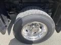 Close-up of a 2010 Ford F-550 tire mounted on a chrome wheel showcasing deep tread pattern and reflective surface