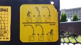 A yellow instruction sign displaying various crane arm positions and movement guidelines