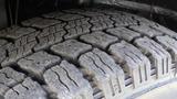 Close-up of a worn tire tread on a 2017 RAM Promaster showing deep grooves and wear patterns