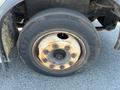 2010 Freightliner MT45 garbage truck tire and wheel showcasing rust on the rim and worn tread on the tire