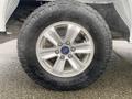 Close-up of a silver alloy wheel and tire on a 2017 Ford F-150 showcasing the tread pattern and Ford logo on the center cap