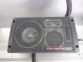A 3-way bass reflex speaker with a black mesh grille featuring a circular and a square speaker design