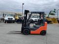 A 2011 Toyota Forklift with orange and gray coloring featuring two long forks positioned forward