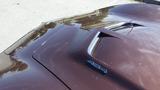 A 1971 Chevrolet Corvette Stingray with a glossy brown finish and a distinctive hood design featuring a vent and a 454 emblem