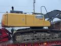 A yellow 2014 John Deere 350G excavator with a black rubber track is shown on a flatbed truck