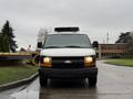 A 2009 Chevrolet Express van with a white exterior and black grill parked facing forward