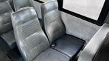 Interior seating of a 2014 Freightliner Thomas Diesel bus featuring two gray vinyl seats with a textured pattern in a row